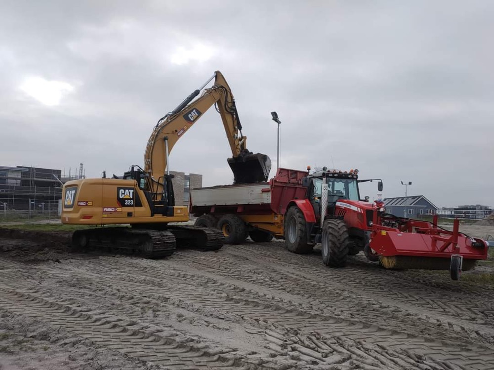 Graafmachine laadt trekker met kipper
